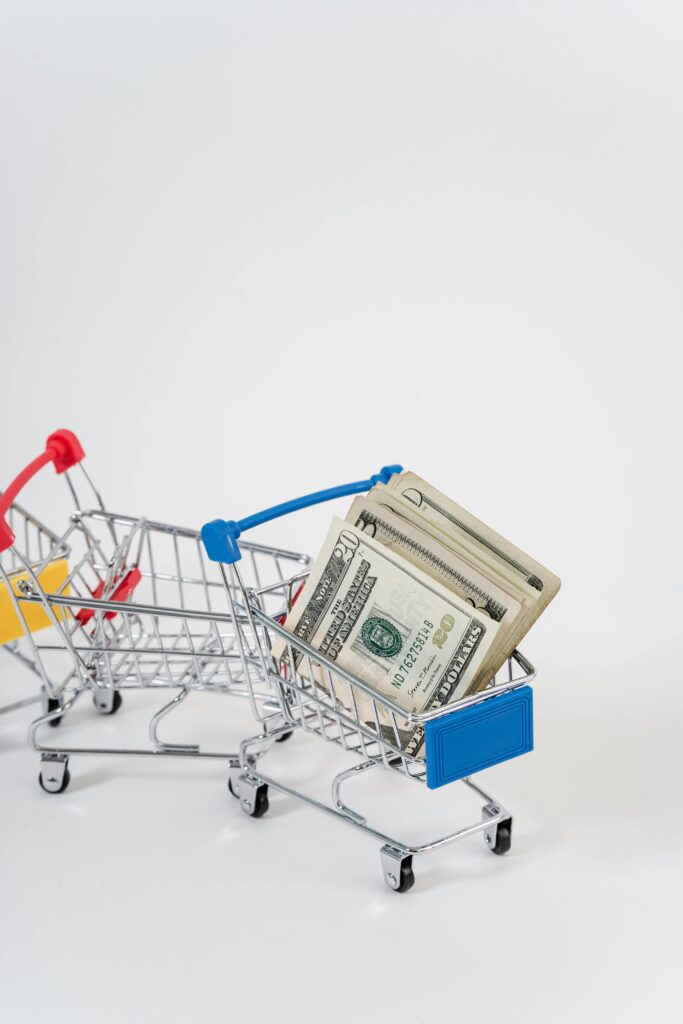 pexels-photo-5926223-5926223 A close-up of miniature shopping carts filled with dollar bills, symbolizing finance and shopping.