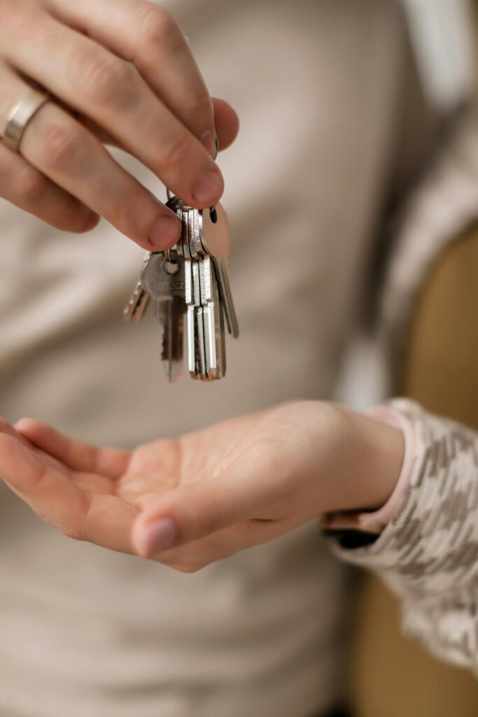 pexels-photo-7641904-7641904 A close-up photograph of hands exchanging keys, symbolizing new home ownership.